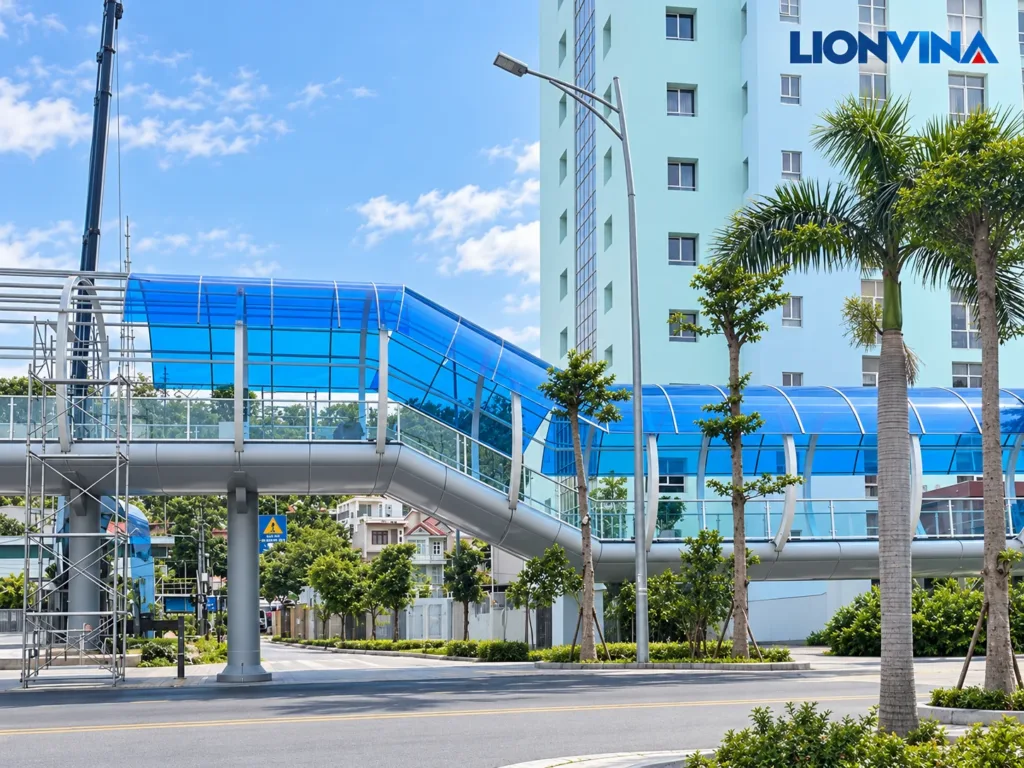 Curved blue pedestrian bridge canopy with LIONVINA logo