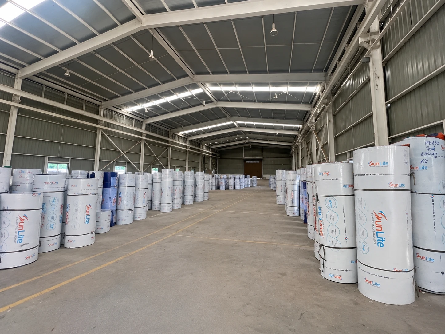Kho thành phẩm với các cuộn tấm SUNLITE xếp hai bên lối đi